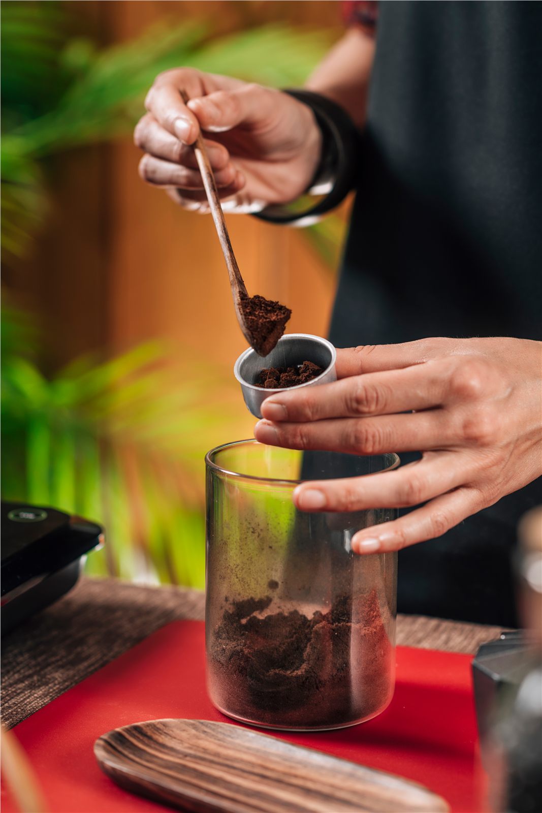 Ground coffee being poured into a glass for brewing